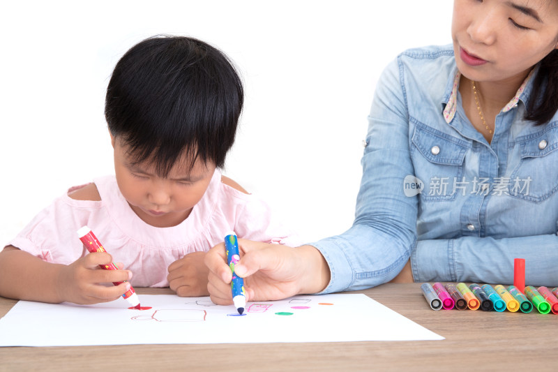 孩子母亲或幼儿园教师在手把手教小女孩绘画