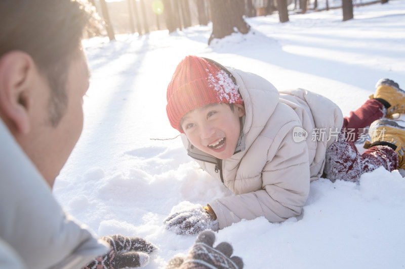 在雪地上玩耍的快乐父子