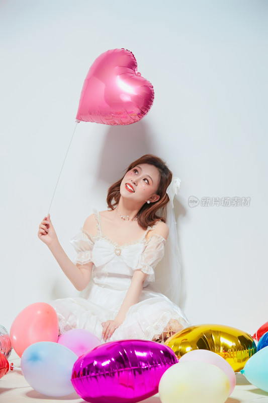 穿着公主裙手拿气球庆祝生日的亚洲女性