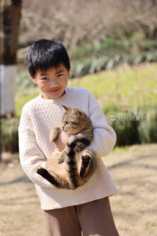 一个中国小男孩和他的宠物猫狸花猫