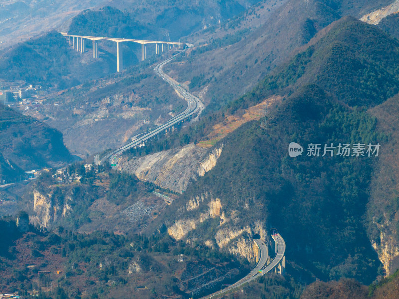 山间城镇全景，高架公路贯穿其中