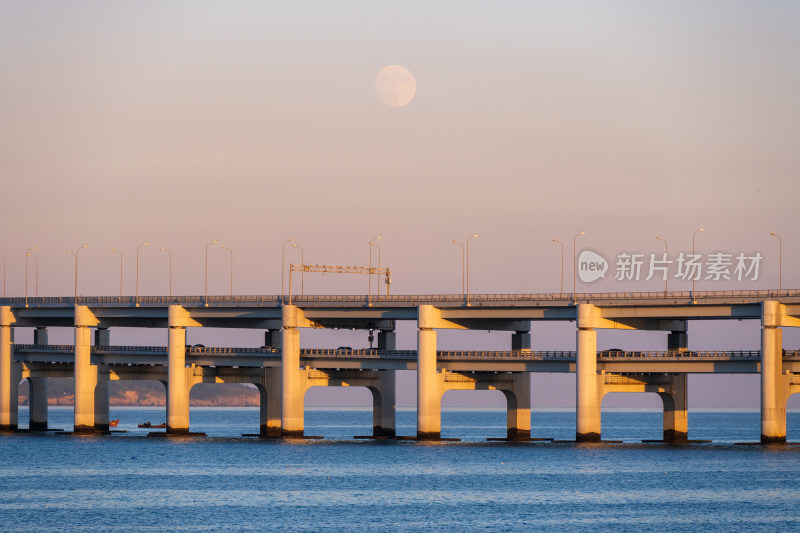 夕阳下大连星海湾大桥上空升起的月亮