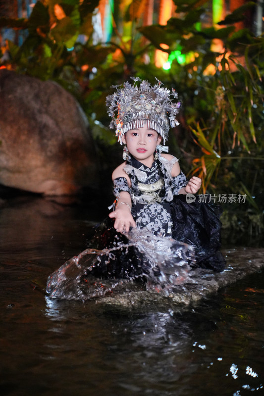 身着苗族服饰女童玩水瞬间