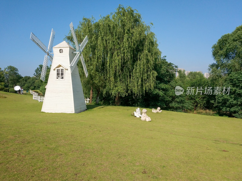 草地中的白色风车与雕像