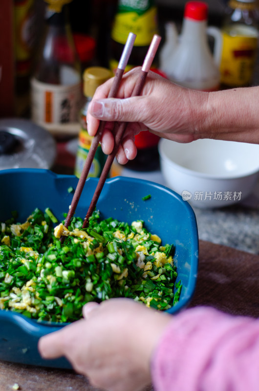 手用筷子搅拌韭菜鸡蛋食材