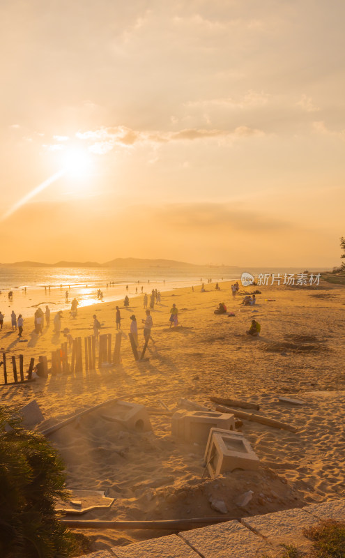 海边夕阳下的人群休闲场景