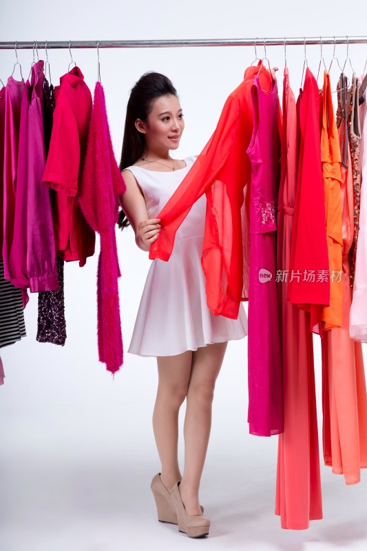 棚拍年轻女人购物选择衣服
