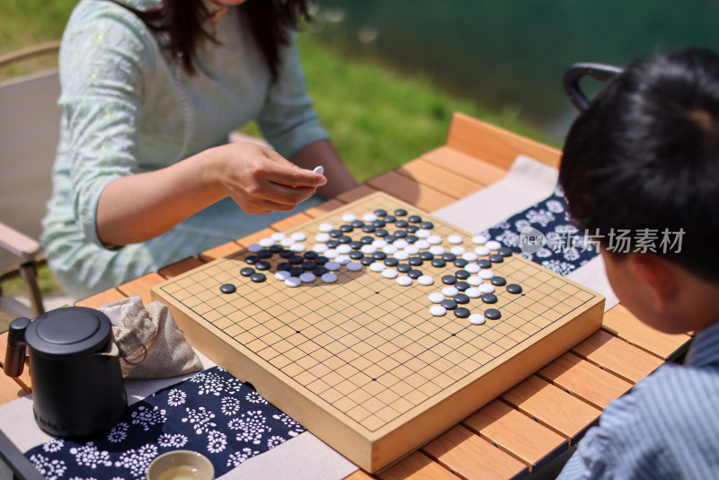 一对在湖边下围棋的母子