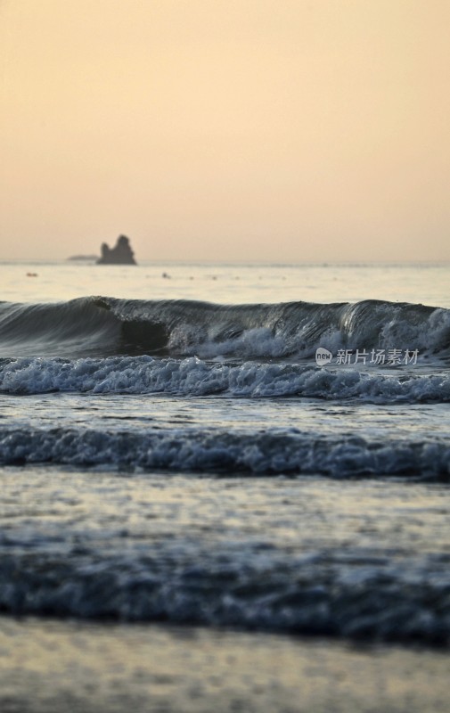 海边夕阳下的海浪与礁石