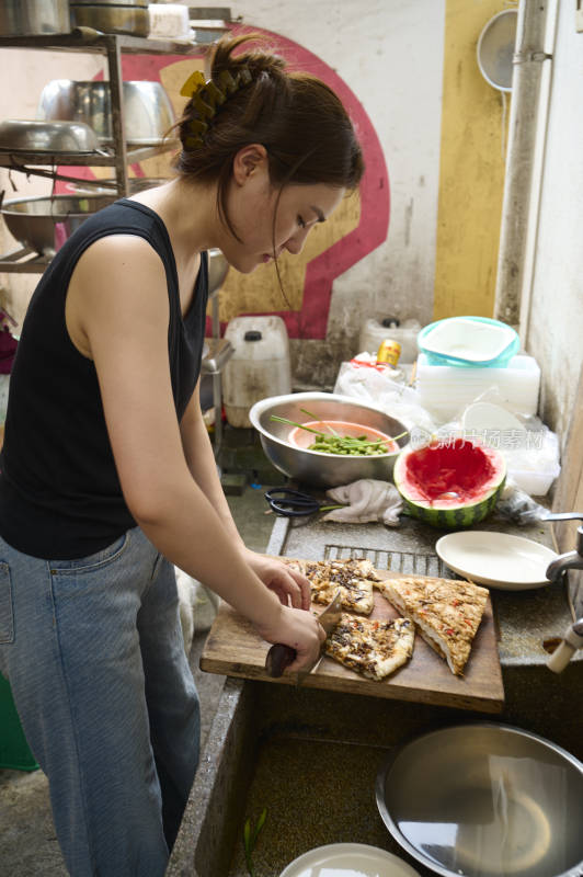 女子在厨房切食物的场景