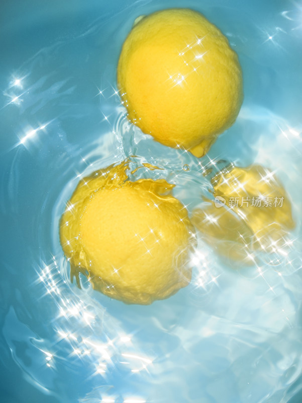 蓝色的水中漂浮着新鲜的黄色柠檬