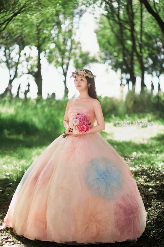 林间手持花束的穿纱裙女子