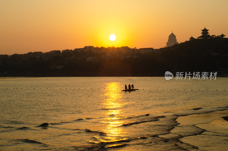 中国青岛汇泉湾落日虾坐着海上脚踏船