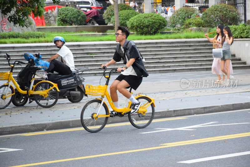 男子骑行黄色共享单车