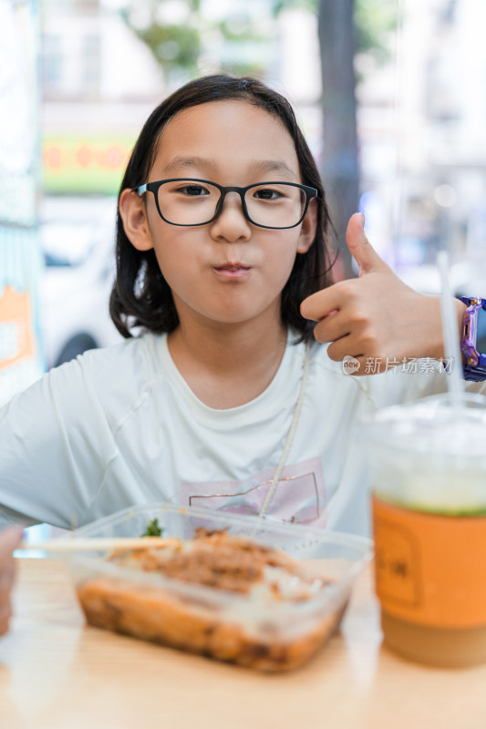 戴眼镜女孩在街边用餐并点赞