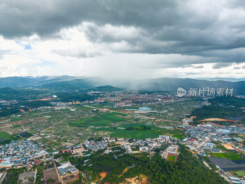 航拍乌云暴雨下的勐海县田园风光