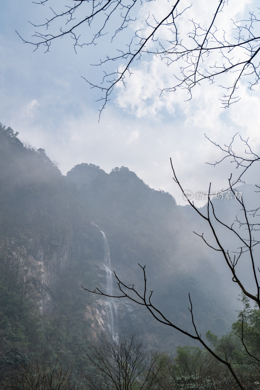 山间瀑布景观，雾气缭绕似仙境