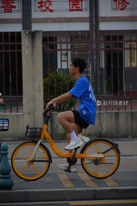 男子骑行黄色共享单车