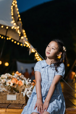 夏季户外露营坐在帐篷前的东方女孩