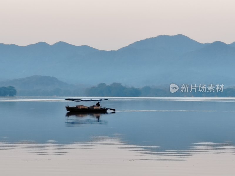 平静湖面上小船漂荡的山水风光