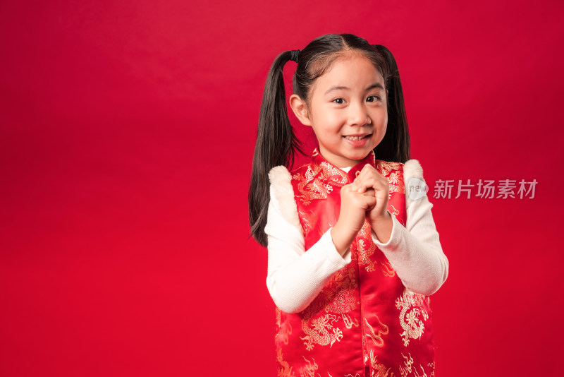 站在红色背景前作揖的中国女孩
