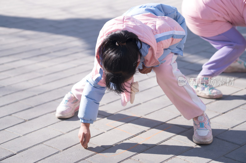 小女孩在地上画画