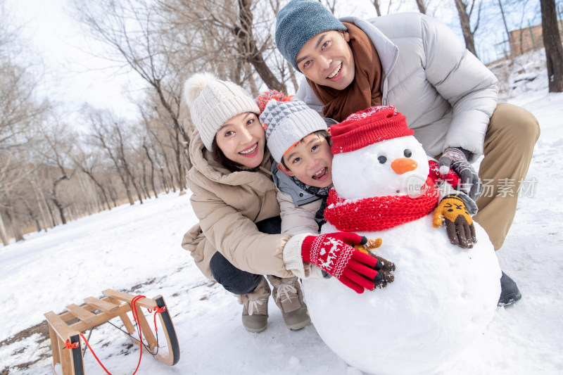 一家三口在雪地里堆雪人