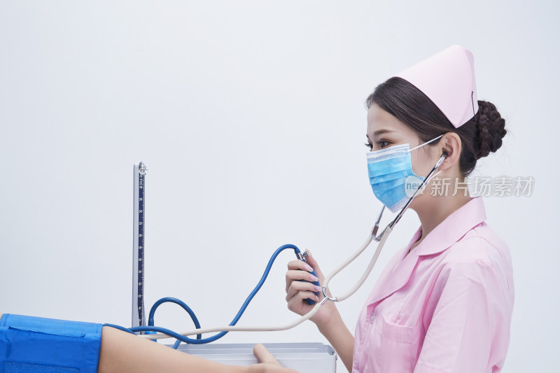 手拿血压测量仪为患者诊治量血压的女性护士