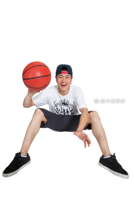 棚拍年轻男人坐在地上玩篮球