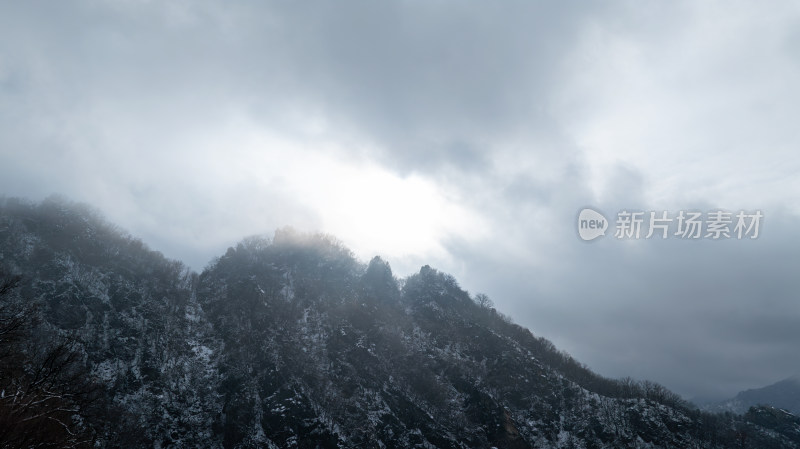 寒冷冬天山顶阳光透过云层