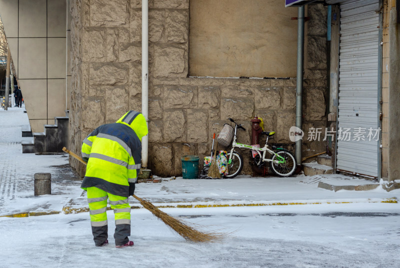 在马路上扫雪的环卫工人