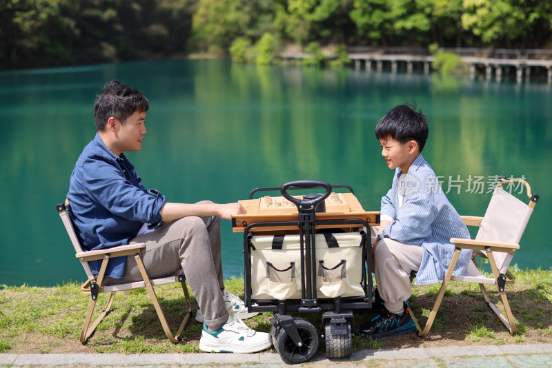 在湖边下棋的父子