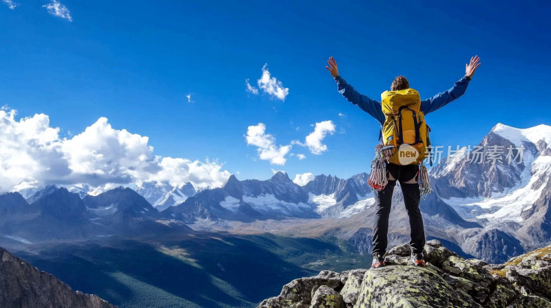 蓝天白云男子登上顶峰张开双臂背影登山人物