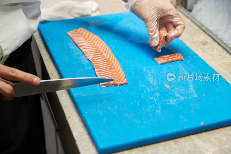 厨师切三文鱼做寿司卷
