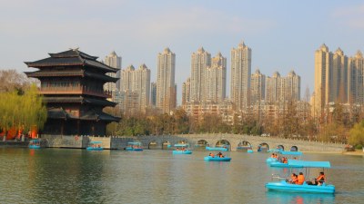 湖边古建筑与游船及高楼景观