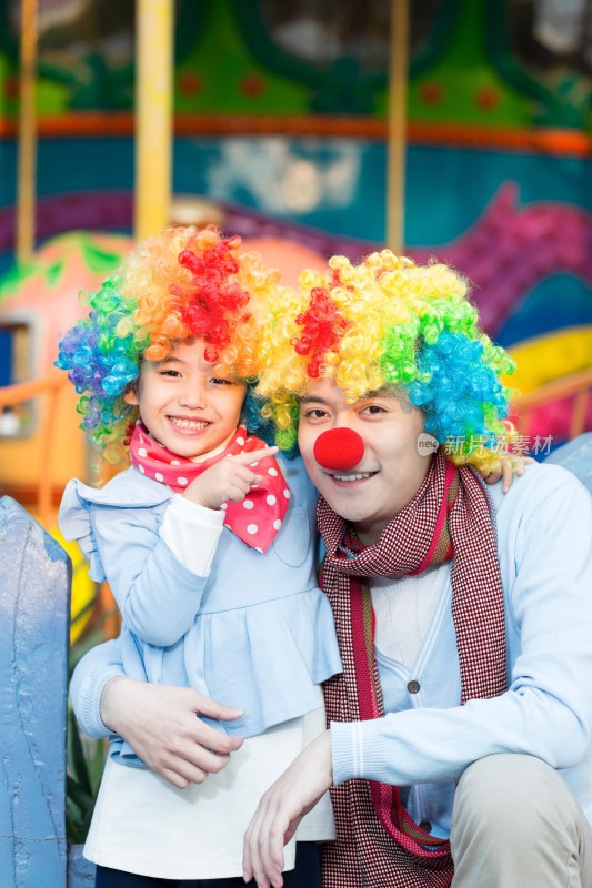 快乐的父女扮小丑在游乐园玩
