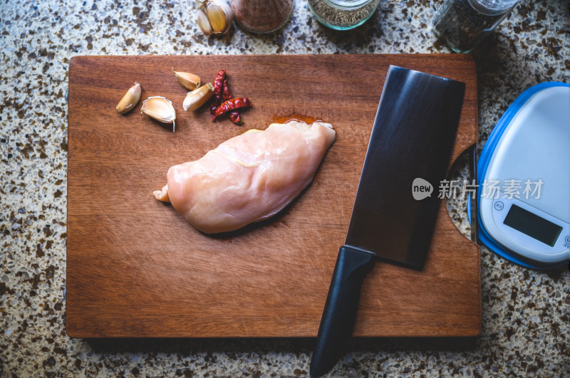 餐饮美食-一块放在厨房案板上的生鸡胸肉