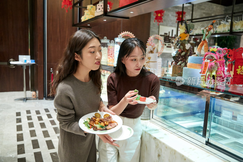 在酒店自助餐厅大吃特吃的亚洲可爱闺蜜少女