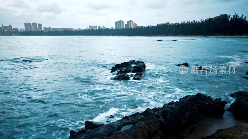 海南陵水清水湾海边礁石与城市远景