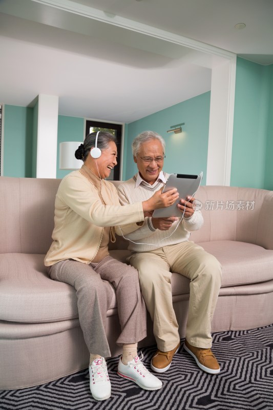 老年夫妻在客厅里使用平板电脑
