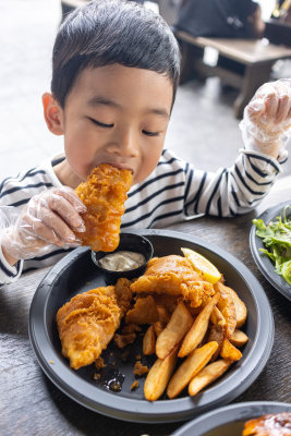 小男孩满足地吃炸鸡薯条