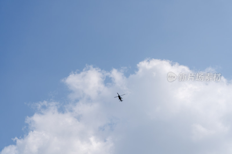 蓝天白云中飞过的直升飞机