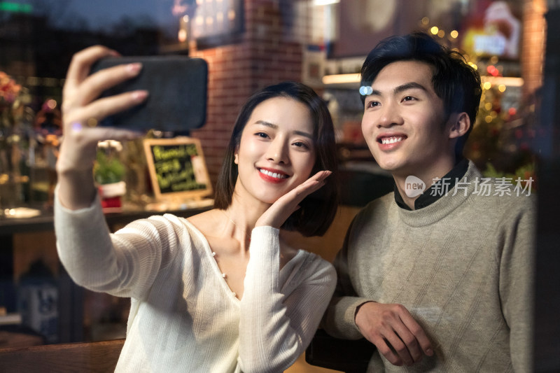 餐厅内的青年伴侣使用手机自拍