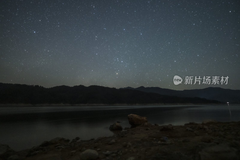 繁星密布的夜空下的山峦与湖水