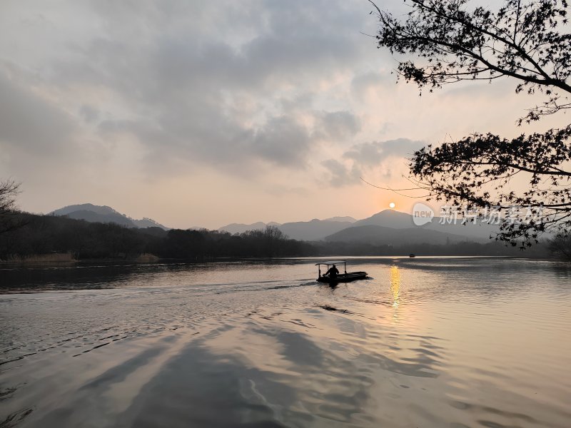 夕阳下湖面上小船独行的山水风光