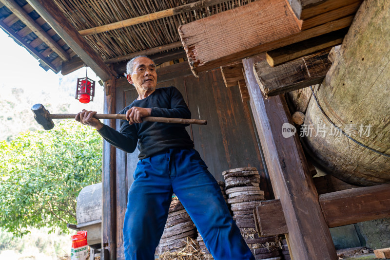 传统油坊榨油老人抡大锤劳作