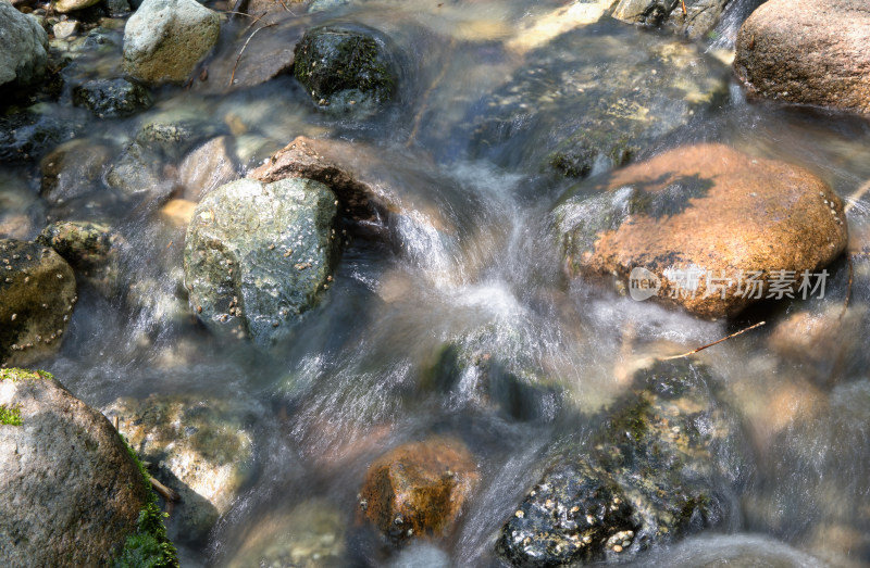 慢门拍摄夏季户外大山里流淌的溪流