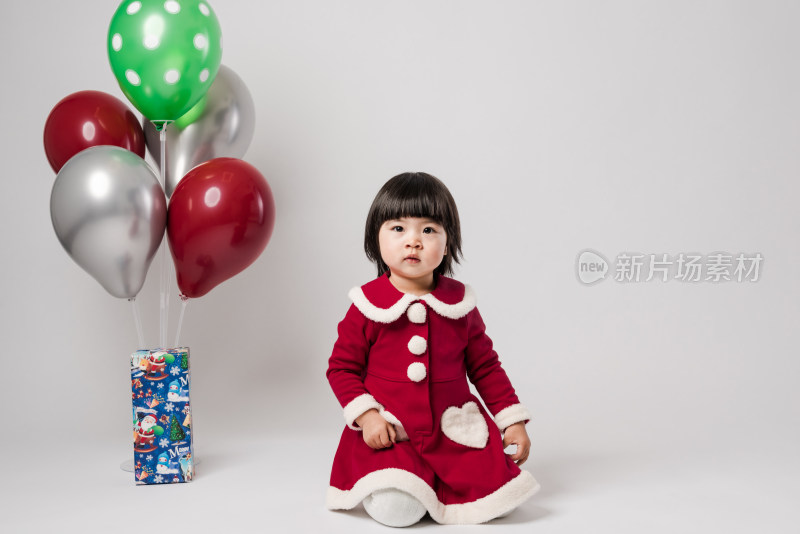 白色背景前穿圣诞礼服的中国女童