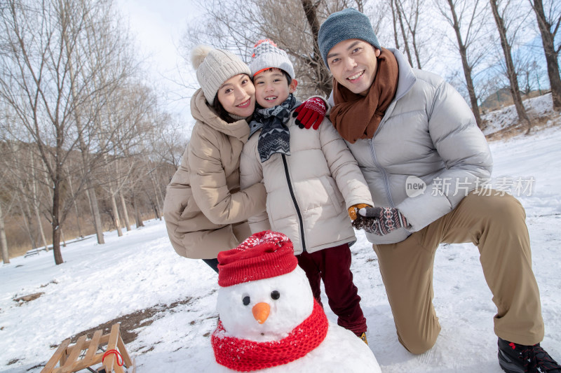 一家三口在雪地里堆雪人