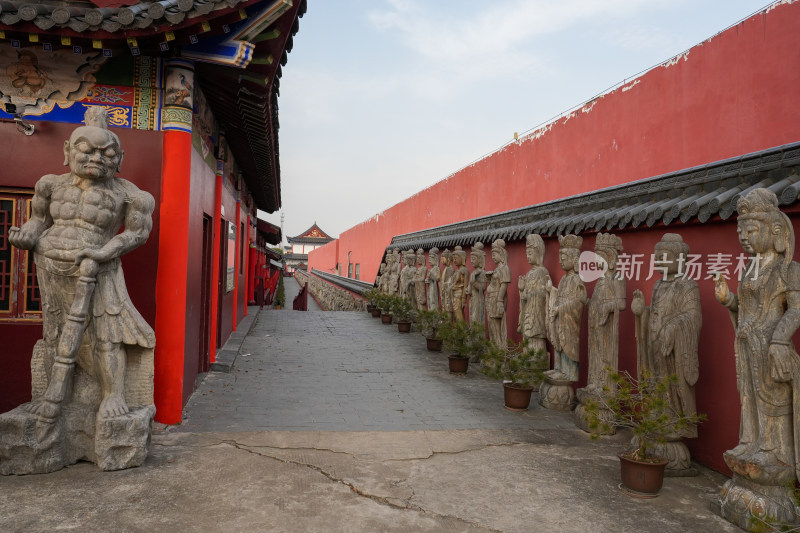 中式古建筑旁的石雕佛像